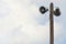 Public address horn loud speakers on wooden pole over blue sky