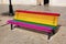 Public bench painted with the rainbow flag of the LGTBI