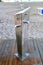 Public foot washing station wooden decking on a sandy beach, for