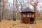 Public gazebo. Wooden pavilion in the autumn forest. Forest rest, picnic.