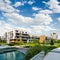 Public green park with modern blocks of flats and blue sky