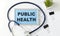 PUBLIC HEALTH CONCEPT Text, On Background of Medicaments Composition, Stethoscope
