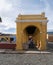 Public lavoir in the town of Antigua Guatemala, yellow walls, people standing under archway