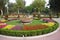 public park with floral arrangement as a centerpiece, attended by visitors