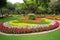 public park with floral arrangement as a centerpiece, attended by visitors