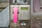 Public pay phone made of scratched metal with a pink handset, insert for coins and credit card, in Germany, copy space