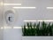 Public payphone for phone cards in a white modern interior with led lights and green plants