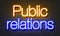 Public relations neon sign on brick wall background.