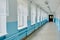 A public school, a long empty corridor with blue walls. The concept of quarantine