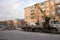 Public service workers put construction waste from the demolition of old pavilions in a truck with a crane on a city street