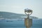 Public stationary binoculars on the seashore, metal binoculars on blurred sea background