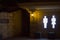 Public toilet wall at night. Large glowing silhouettes of people at the entrance