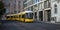 Public transportation concept. Yellow electric tram travels at Berlin`s town, Germany. Buildings background, banner