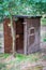 Public wooden outhouse toilet with heart cutout in door