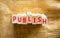 Publish symbol. The concept word Publish on wooden blocks. Beautiful canvas background, copy space. Business publish and