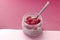 Pudding chia with coconut milk and raspberries on the pink background.