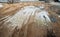 Puddle and mud with truck wheel track at construction site in rainy day