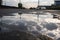 puddle of water on asphalt after rain storm, with reflection of cloudy sky