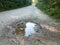 Puddle with water on gravel trail or path