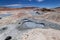 The puddles of boiling mud of the Sol de MaÃ±ana Geysers. Snow-capped volcanoes and desert landscapes in the highlands of Bolivia