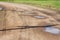 Puddles and mud on the gravel road after rain on countryside