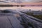 puddles on the shore and beautiful sunset on Lake Ladoga in Karelia, Russia in the Ladoga Skerries national park in summer.