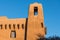 Pueblo style adobe building and tower with rustic beams in Santa Fe, New Mexico