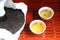 Puer tea. Packed pancake of traditional chinese puer tea with white teaput. Asian pressed pu-erh tea and crockery tea set, clay