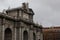 Puerta de Alcala neoclassical monument under the clouded sky in Madrid, Spain