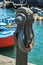 Puerto de la Cruz, Tenerife, Spain - July 10, 2019: Rust anchor in the Old port of town. Small fishing boats of local people.