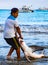 Puerto Lopez, Ecuador / Aug 19, 2016: Fisherman drags a dead shark onto the beach for processing