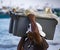 Puerto Lopez, Ecuador - Aug 19, 2016: Man carries bin of fish up the beach from the boat to the waiting processor trucks