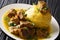 Puerto Rican Mofongo made from plantains, garlic and chicharron served with meat and broth close-up. horizontal