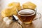 Puff cookies  sugar cubes  spoon  transparent cup with tea on wooden table