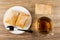 Puff pastries, spoon in white plate, transparent cup with tea on table. Top view