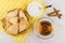 Puff pastry in basket, tea, sugar, spoon in bowl, cinnamon