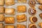 Puff pastry rolls. fresh sweet baking on papyrine. Several kinds of crispy pies lie in rows on a baking sheet on the counter. Top