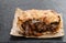 Puff pastry steak pie on baking paper on black stone background