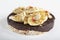 Puffed exploded wheat grains with chocolate glaze with muesli and cut banana slices on a light wooden background.