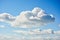 Puffy cumulous clouds billowing across a blue sky