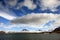 Puffy white clouds, blue sky, mountain peaks and glaciers in the arctic Svalbard