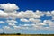 Puffy white clouds & blue sky over remote australian outback, no