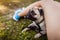 Pug dog hiding under master`s legs on grass. Happy puppy having fun with master