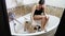 Pug dog washing. Woman bathes the cute pug. Wet dog shaking