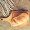 Pugliese Apulian bread with biga on a wooden cutting board, near