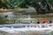 PULHAPANZAK, HONDURAS - APRIL 18, 2016: People are bathing in a river above Pulhapanzak waterfal