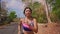 Pull back gimbal shot in dolly style of young exotic fit and beautiful Asian Indonesian woman running on trail road jogging