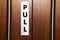 A pull sign on a door in a public building.