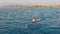 Pulled out of the water on Board a boat, a young woman swims behind a boat holding on to a rope