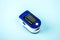 Pulse oximeter to measure pulse rate and oxygen levels isolated on blue background. Medical concept. Diagnosing coronavirus